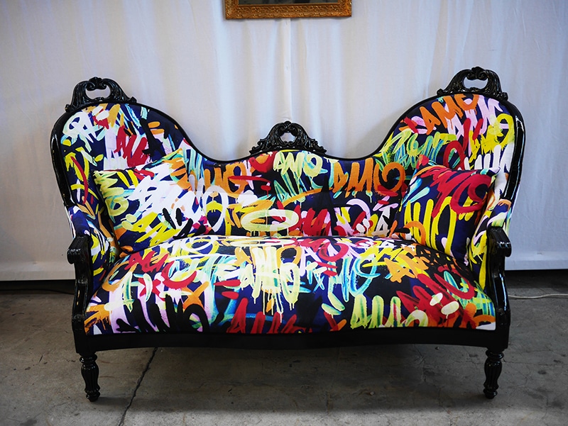 Canapé tapissé par les peintures de l'artiste A-MO.