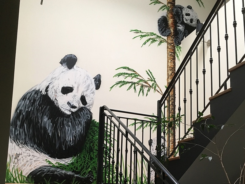 Pandas peints dans une cage d'escalier par l'artiste A-MO.
